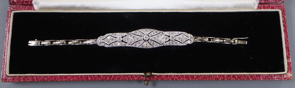 A 1930s pierced white metal and diamond set bracelet, on an 18ct expanding bracelet, 14.4cm ++, gross 11.8 grams.